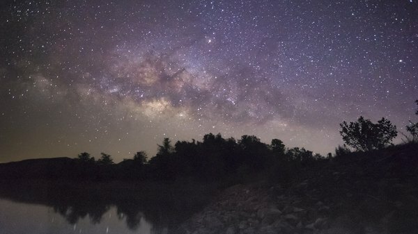 galaxis erdővel körvonalazódott a sötétségben