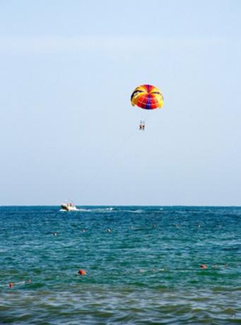 Parasailer sering terlihat di sepanjang pantai.