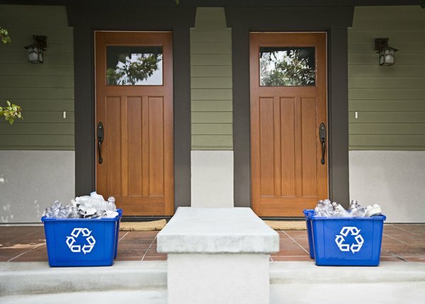 Recyclingbakken staan ​​buiten twee huizen.
